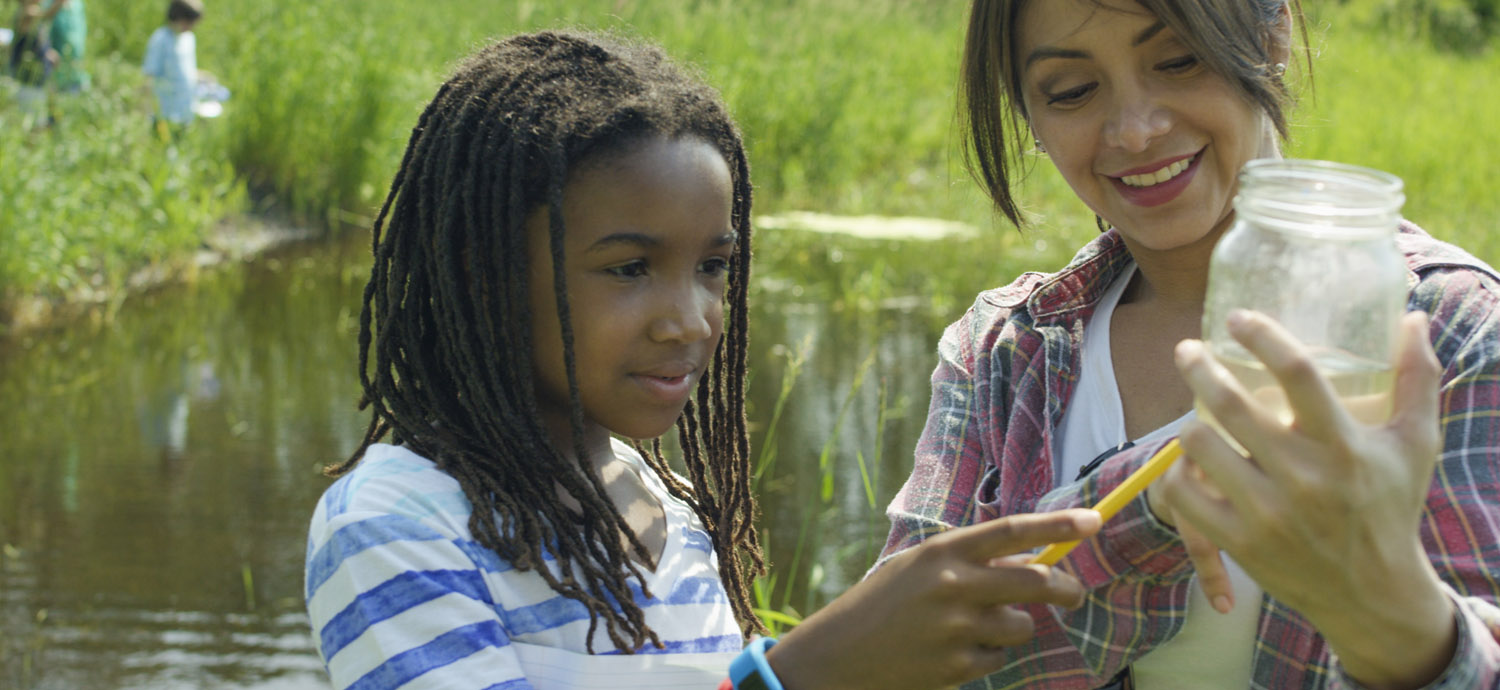 Student and teacher examining pond life
